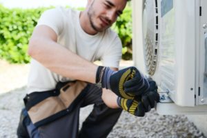 HVAC contractor replacing an AC system during the fall season