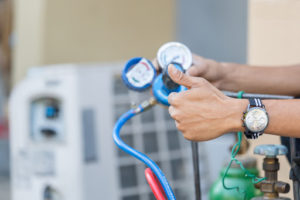 A person is completing AC maintenance and giving a thumbs up that indicates a well-functioning system.